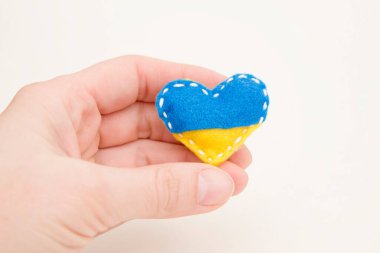 Ukrayna bayrağı teması. Kalp şeklindeki rozet mavi ve sarı dolgulu keçeden yapılmış. Savaş konuları. Özgürlük savaşçıları. Ulusların desteği, birlik. Barış için dua et. Savaş yok..