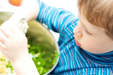 Çocuk salata yapıyor. Çelik ağla yumurta doğrama. Çocuklar için yemek terapisi. Doğal organik duyusal alet. Yemek hazırlama meditasyonu.