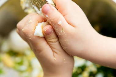 Çocuk salata yapıyor. Çelik ağla yumurta doğrama. Çocuklar için yemek terapisi. Doğal organik duyusal alet. Yemek hazırlama meditasyonu.