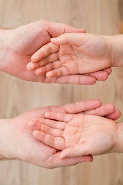 Çocukların elleri babanın avuçlarında. Ebeveynlik, arkadaşlık, vesayet, yetiştirme, ebeveyn-çocuk ilişkisi, aile bağı.