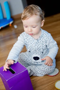 Para kutusu. Genç ekonomist para biriktirme kutusuna oyuncak paralar yerleştiriyor. Yatırım, ekonomi, enflasyon, bankacılık. Emeklilik ve emeklilik planlama. Para üretimi, iş dili.