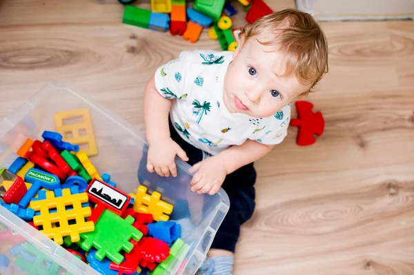 Bebek oyuncaklarla oynuyor. Hangi oyuncağı seçsem? bebek oyuncak kutusu içeriğini kontrol ediyor.