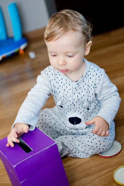 Para kutusu. Genç ekonomist para biriktirme kutusuna oyuncak paralar yerleştiriyor. Yatırım, ekonomi, enflasyon, bankacılık. Emeklilik ve emeklilik planlama. Para üretimi, iş dili.