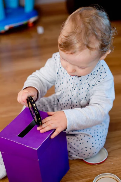 Para kutusu. Genç ekonomist para biriktirme kutusuna oyuncak paralar yerleştiriyor. Yatırım, ekonomi, enflasyon, bankacılık. Emeklilik ve emeklilik planlama. Para üretimi, iş dili.