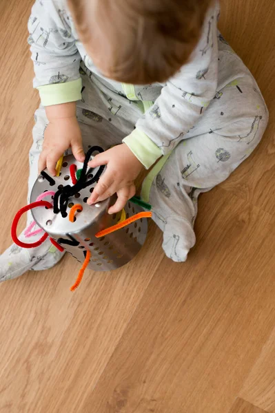 Küçük oğlan oynuyor. El becerilerini geliştirir..