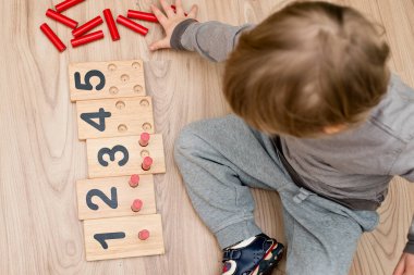 Montessori metodolojisinin ahşap figürleri. Matematik çocukları çocuklar için bulmaca sayıyor. Geliştirilmesi gereken bilgisayar oyunları eğitimi. Zeki bir çocuk matematik oyuncağı. Sayı oyunu tahtası.