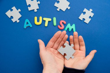Otistik çocuk elleri yapboz, kelime otizmi, akıl sağlığı konsepti. Otizm spektrumu, düzensizlik. Dünya Otizm Farkındalık Günü.