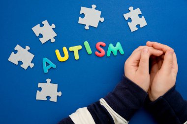 Otistik çocuk elleri yapboz, kelime otizmi, akıl sağlığı konsepti. Otizm spektrumu, düzensizlik. Dünya Otizm Farkındalık Günü.
