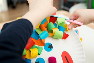 Kağıt tabak palyaçosu. Evde oyunlar, anaokulu çocukları için aktiviteler. Beş dakikalık el işi. Çocuklar palyaço için saç kesmek eğlenceli ve eğlencelidir. Kırmızı Burun Günü teması.