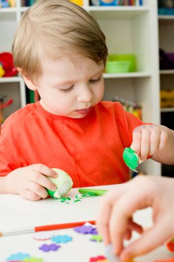 Mutlu Paskalyalar. Paskalya yumurtası boyayan 3 yaşında bir çocuk. Dini bayram. Erken eğitim ve sanatsal anaokulu aktiviteleri.