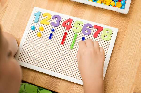 ピンを挿入する数字の少年によって 家で遊べ 遊びを通して 子どもたちのために良い電動スキル 論理的な思考を開発するために実装します 想像力創造力を刺激する — ストック写真