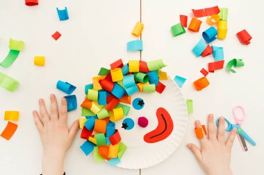 Kağıt tabak palyaçosu. Evde oyunlar, anaokulu çocukları için aktiviteler. Beş dakikalık el işi. Çocuklar palyaço için saç kesmek eğlenceli ve eğlencelidir. Kırmızı Burun Günü teması.