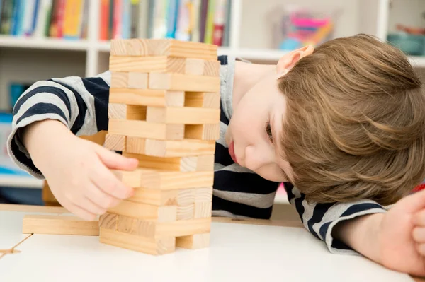 Criança Constrói Uma Torre Jogo Tabuleiro Feito Blocos Madeira Desenvolva — Fotografia de Stock