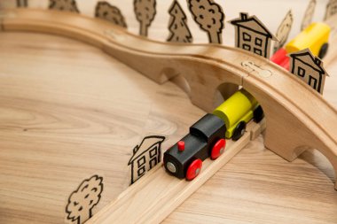 Buharlı trenli ahşap demiryolu. Ahşap zeminde çocuk oyuncağı. Çocuk odası teması. Dikkatsiz çocukluğun, hayallerin, savaşın ve kolay hayatın sembolü..