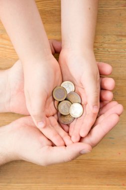 Adult giving coin to a child as saving money concept. Children's financial education, financial literacy. Payment for duties performed.
