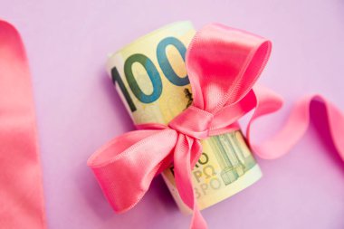 Konsept, para hediye olarak, kazanmak ya da ikramiye olarak. Kırmızı kurdeleli 100 dolarlık banknotları alır ya da verir..