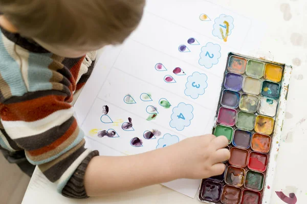 Erken eğitim, sayı saymayı öğrenmek. 2 yaşındaki bir çocuk doğru sayıda pul koyar. Çocuklar, insanlar, bebeklik ve eğitim kavramı. Çocuğun oluşumu ve gelişimi.