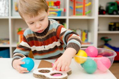 Dondurmada değiştirilebilir renkler. Doğru topları bul. Küçük çocuk istifleme malzemeleriyle oynuyor. Erken eğitim için montessori metodoloji. yürümeye başlayan çocuğun anlamlı görünüşü.