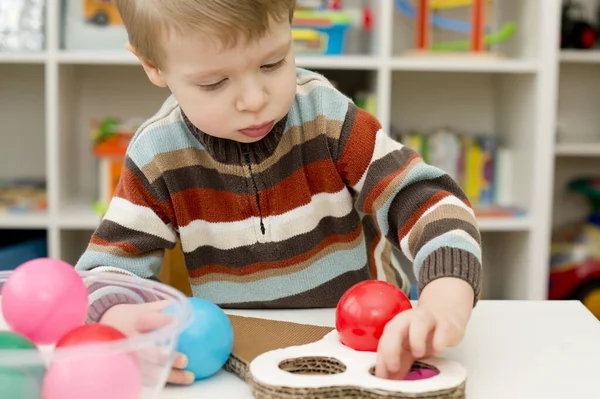 Dondurmada değiştirilebilir renkler. Doğru topları bul. Küçük çocuk istifleme malzemeleriyle oynuyor. Erken eğitim için montessori metodoloji. yürümeye başlayan çocuğun anlamlı görünüşü.