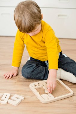 Bulmaca numaraları. Çocuk ahşap numaralarla oynuyor. Erken eğitim, sözlü ve hafıza oyunu.