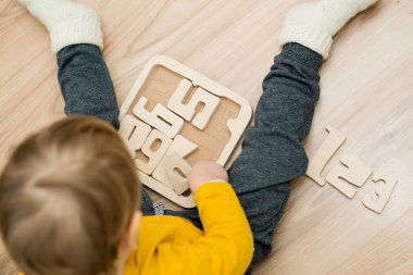 Bulmaca numaraları. Çocuk ahşap numaralarla oynuyor. Erken eğitim, sözlü ve hafıza oyunu.