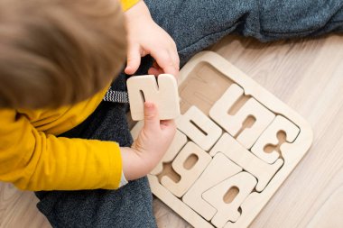 Bulmaca numaraları. Çocuk ahşap numaralarla oynuyor. Erken eğitim, sözlü ve hafıza oyunu.