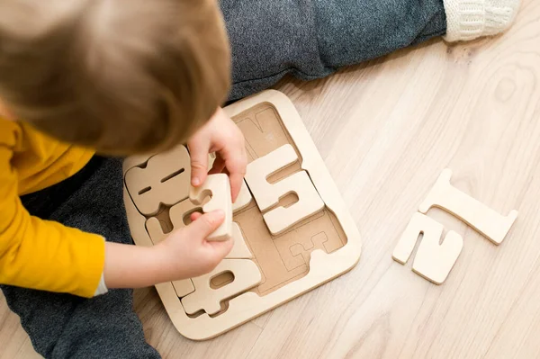 Bulmaca numaraları. Çocuk ahşap numaralarla oynuyor. Erken eğitim, sözlü ve hafıza oyunu.