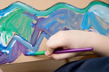 Sıfır kayıp. Arazi yapmak için oyulmuş karton kesilmiş ve yapıştırılmış. Çocuk onu deniz gibi boyuyor. Evdeki DIY oyunları. Okyanus konseptini koru.