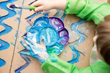 Sıfır kayıp. Arazi yapmak için oyulmuş karton kesilmiş ve yapıştırılmış. Çocuk onu deniz gibi boyuyor. Evdeki DIY oyunları. Okyanus konseptini koru.