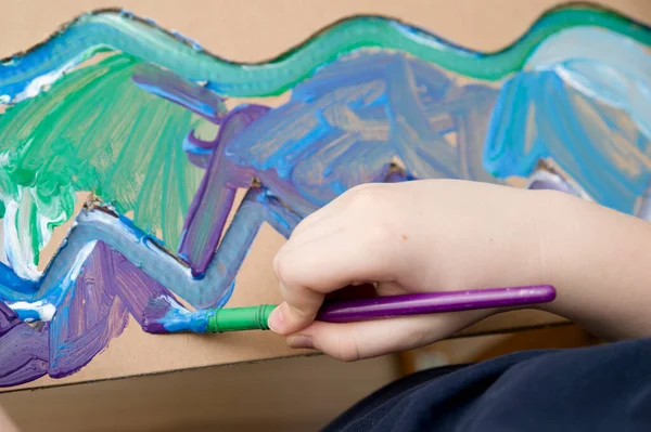 Sıfır kayıp. Arazi yapmak için oyulmuş karton kesilmiş ve yapıştırılmış. Çocuk onu deniz gibi boyuyor. Evdeki DIY oyunları. Okyanus konseptini koru.