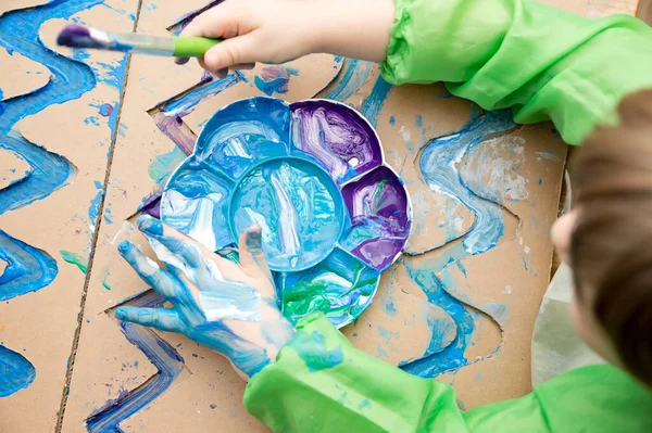 Sıfır kayıp. Arazi yapmak için oyulmuş karton kesilmiş ve yapıştırılmış. Çocuk onu deniz gibi boyuyor. Evdeki DIY oyunları. Okyanus konseptini koru.