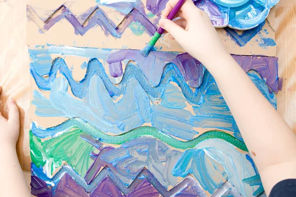 Sıfır kayıp. Arazi yapmak için oyulmuş karton kesilmiş ve yapıştırılmış. Çocuk onu deniz gibi boyuyor. Evdeki DIY oyunları. Okyanus konseptini koru.