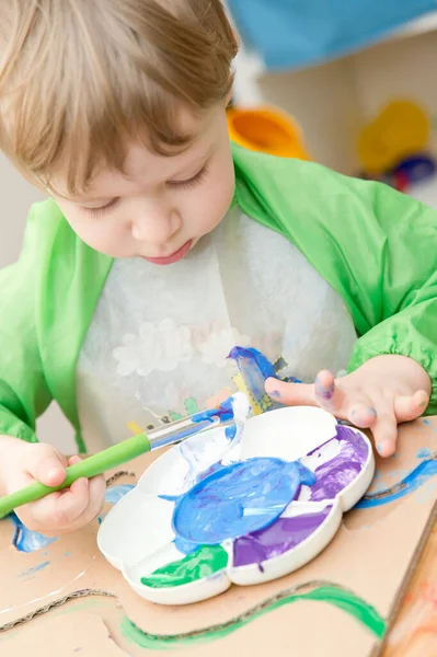 Sıfır kayıp. Arazi yapmak için oyulmuş karton kesilmiş ve yapıştırılmış. Çocuk onu deniz gibi boyuyor. Evdeki DIY oyunları. Okyanus konseptini koru.