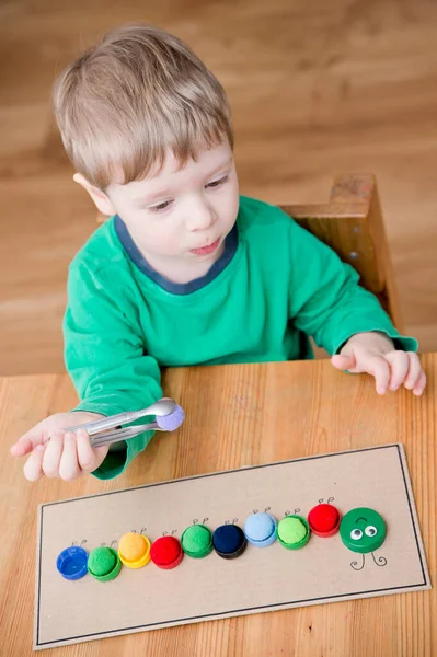 Plastik şişe kapağı solucanı. Doğru renk ponponları kırkayak tırtılına koyun. Beş dakikalık el işi. Çocuk yuvası aktivitesi. Erken eğitim, iyi motor becerileri. # Evde kal.