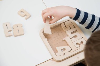 Bulmaca numaraları. Çocuk ahşap numaralarla oynuyor. Erken eğitim, kelime ve hafıza oyunu. Montessori matematik aleti. Tahta oyuncaklar.
