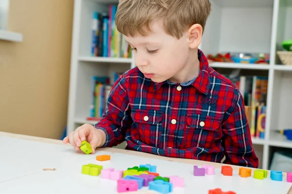 Çocuk oyun yoluyla numaraları öğreniyor. Tahta sayılar ve ayakkabı bağcıklarıyla duyusal aktivite. Evde eğitim, okul öncesi eğitim, Montessori metodolojisi. sayılar dizisi, aritmetik problemler.