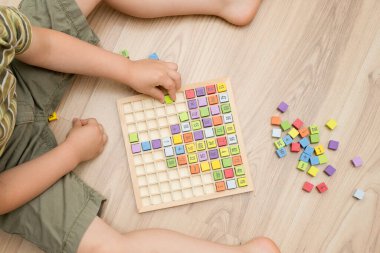 Mats eğitici bir oyun. İyi motor becerileri geliştirmek, mantıklı düşünmek, ilkokul öğrencileri ve hevesli matematik uzmanları için bir araç. Sayılar, rakamlar, temel aritmetik işlemleri içeren renkli tahta küpleri