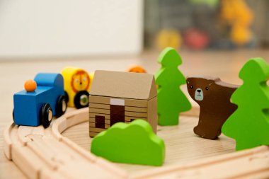 Wooden railway and train with animal wagons on wooden floor. Nostalgia toy from childhood.