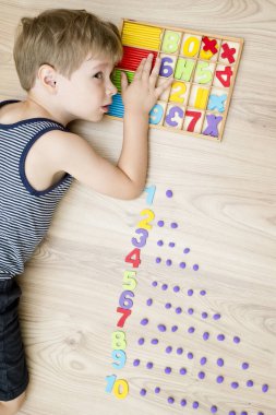 Play-Doh stones and numbers. Counting DIY game. Mathematical task. Play at home. Way of learning. Kid flatten balls when saying a digit.