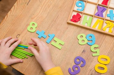 Anaokulu ve anaokulu için favori matematik aletleri ve oyuncakları. Tahta sayma çubukları, sayılar ve denklem sembolleri.
