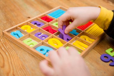 Anaokulu ve anaokulu için favori matematik aletleri ve oyuncakları. Tahta sayma çubukları, sayılar ve denklem sembolleri.