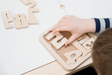 Bulmaca numaraları. Çocuk ahşap numaralarla oynuyor. Erken eğitim, kelime ve hafıza oyunu. Montessori matematik aleti. Tahta oyuncaklar.