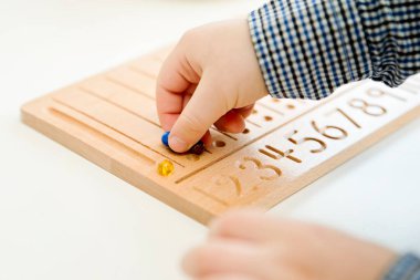 Montessori Boncuklar Kurulu. Sayıları saymayı ve yazmayı öğrenmek, çocuğu zihinsel aritmetiğe hazırlamak, bir düzen, odaklanma, koordinasyon ve doğruluk duygusu geliştirmek.