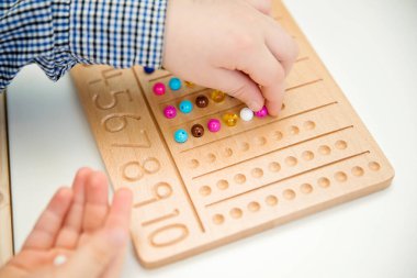 Montessori Boncuklar Kurulu. Sayıları saymayı ve yazmayı öğrenmek, çocuğu zihinsel aritmetiğe hazırlamak, bir düzen, odaklanma, koordinasyon ve doğruluk duygusu geliştirmek.