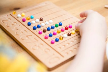 Montessori Boncuklar Kurulu. Sayıları saymayı ve yazmayı öğrenmek, çocuğu zihinsel aritmetiğe hazırlamak, bir düzen, odaklanma, koordinasyon ve doğruluk duygusu geliştirmek.