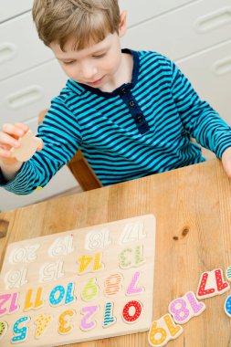 Çocuk oyun yoluyla numaraları öğreniyor. Ahşap sayılarla etkinlik. Evde eğitim, okul öncesi eğitim, Montessori metodolojisi. Saymayı öğrenmek ve hayal gücünü ve yaratıcılığı canlandırmak için.