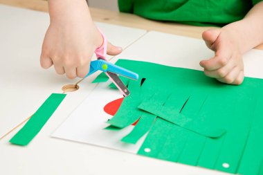 Kirpi çimenlerde saklanır. Küçük bir çocuk kağıt keser. Hayvanların özgürlüğü. İyi motor beceriler geliştirmek, makasla kesmeyi öğrenmek, hayvanları tanımak için..