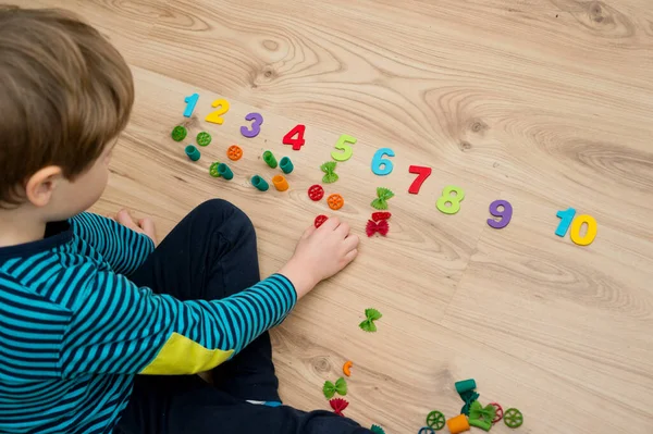 Matematik ve eğlence. Renkli doğal ahşap numaralarıyla pişmemiş makarnanın hesaplanması ve işaretlenmesi. Kendin-yap oyunu. Evde oyna. Öğrenmenin yolu.