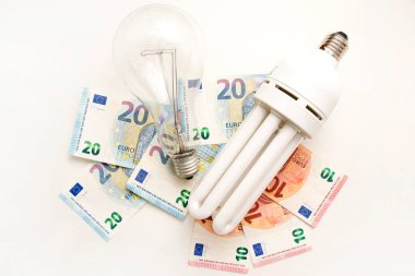 Avro banknotlarında ampul. Elektrik maliyeti ve pahalı enerji kavramları. Artan tüketim, enerji krizi. Enflasyon. Fiyat seviyesi her yıl daha pahalı oluyor..