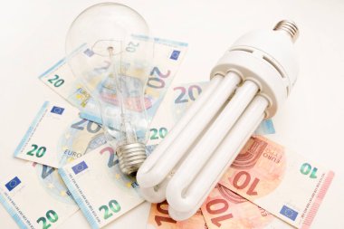 Avro banknotlarında ampul. Elektrik maliyeti ve pahalı enerji kavramları. Artan tüketim, enerji krizi. Enflasyon. Fiyat seviyesi her yıl daha pahalı oluyor..